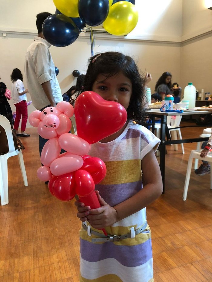 Child holding a balloon character and heart