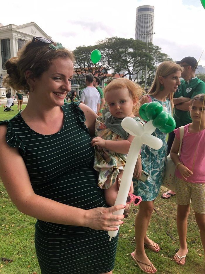 Artist handing a balloon sword to children