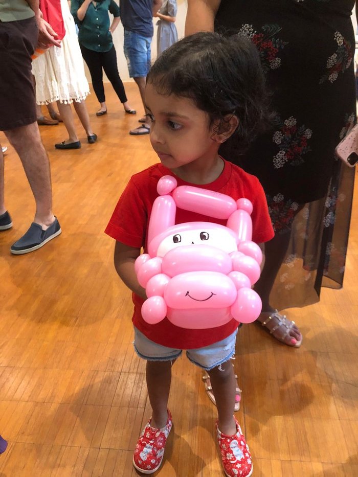 Girl holding a balloon animal she was just given