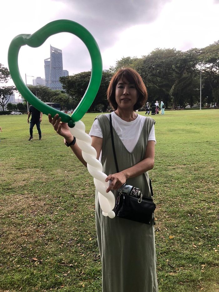 Guest holding a large balloon heart in the park