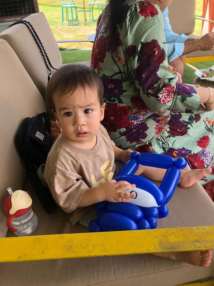 Toddler holding a blue balloon sculpture