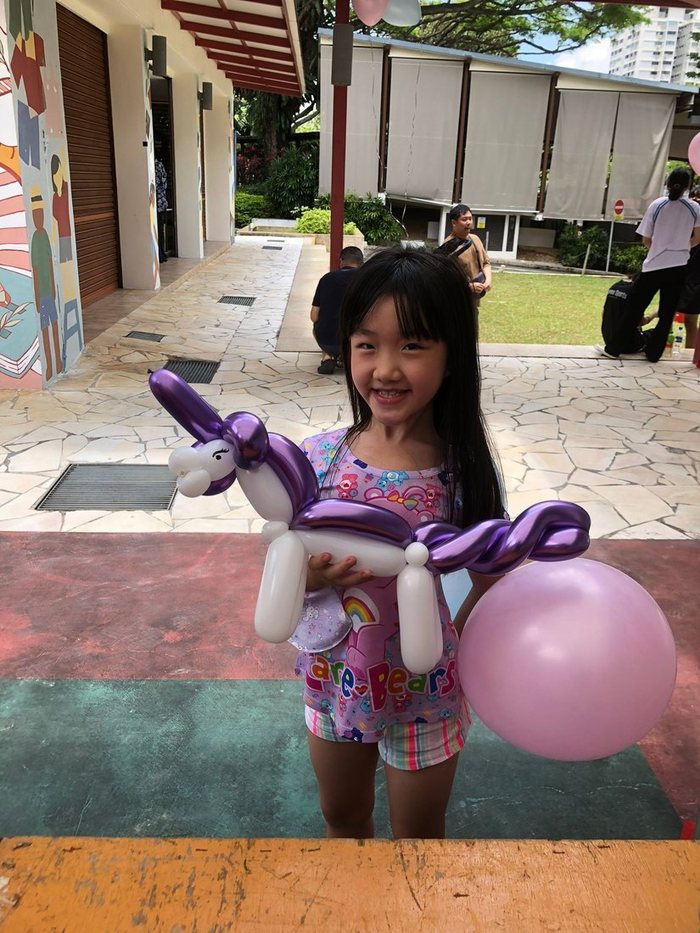 Girl holding a purple balloon unicorn