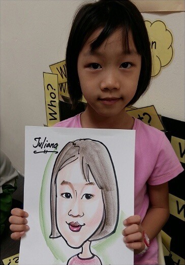 Girl holding up the caricature drawn of her