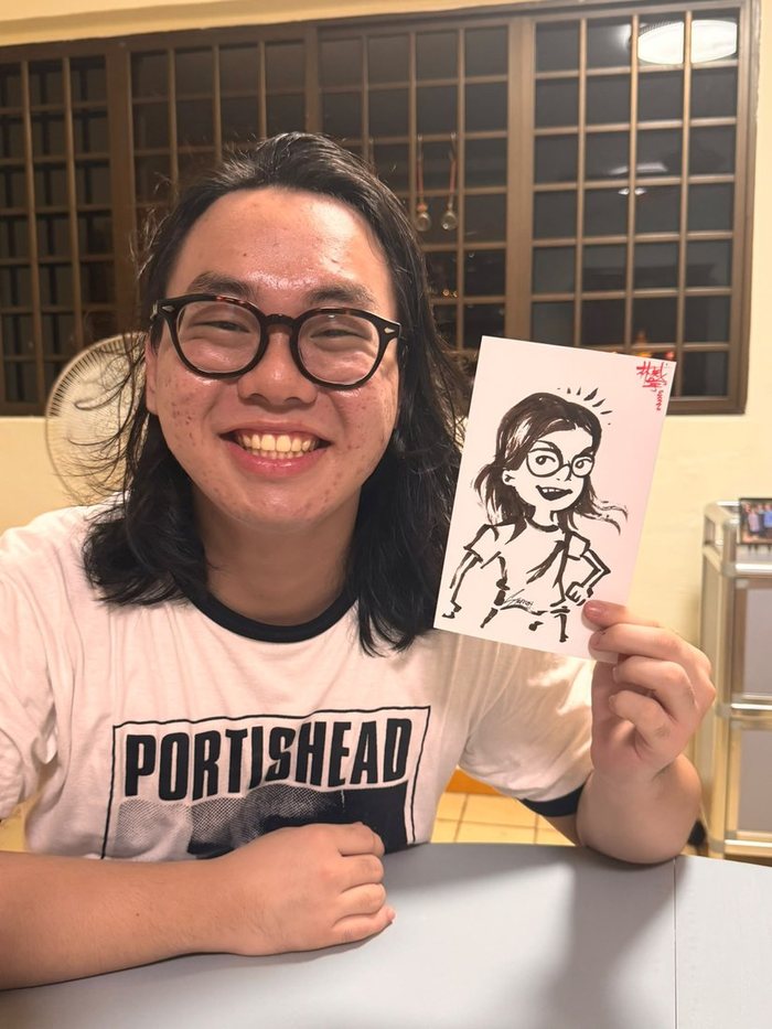 Guest holding the caricature drawn of him at a party
