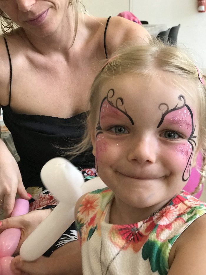 Girl with butterfly face paint at a party
