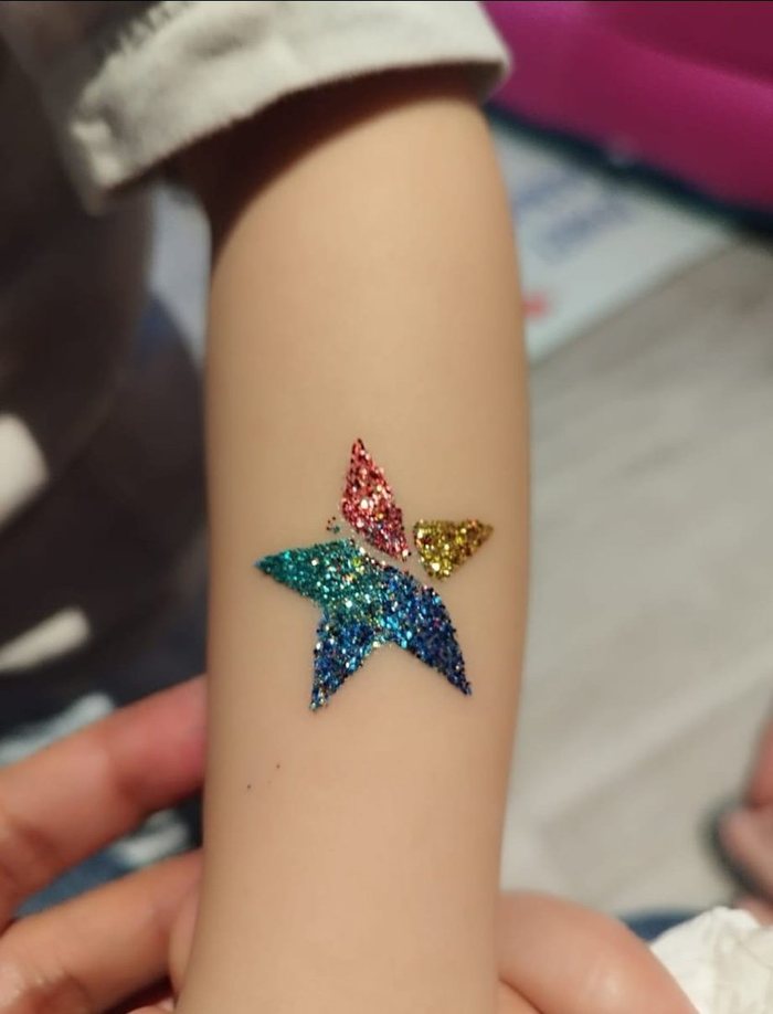 Glitter tattoo star on a child's arm