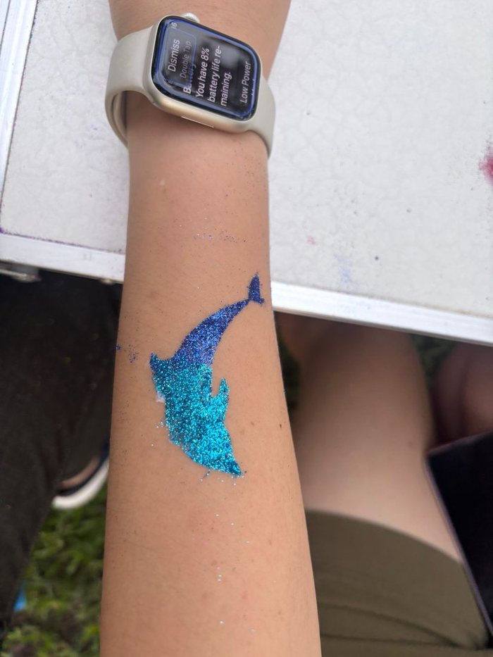 Glitter tattoo dolphin on a child's arm