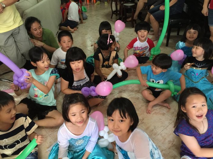 Room full of children holding their balloon sculptures